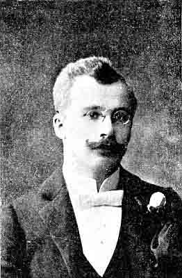 Round pince-nez, close-trimmed handlebar mustasche; formal wear, white bow tie, white rose bud.