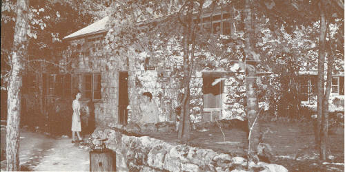 The stone administration building, which has been erected near the entrance to the caverns, was built by hand from the solid rock foundation to the hand-riven cypress shake roof. The walls are built of beautifully weathered native limestone and the shelter roof is supported by hand-hewn timbers prepared on the ground. Parties, who tour the caverns, join guides here and return after the tour.