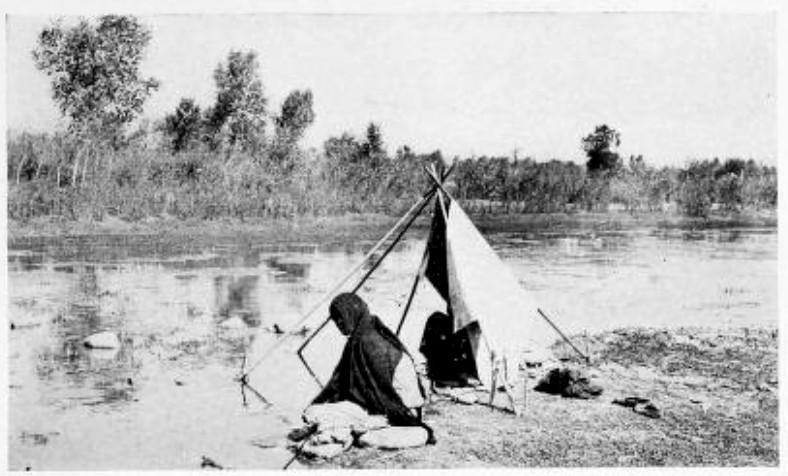 INDIAN WOMEN, POUNDING CLOTHES UPON THE ROCKS BESIDE A
SHALLOW BROOK, CEASED THEIR WORK TO STARE