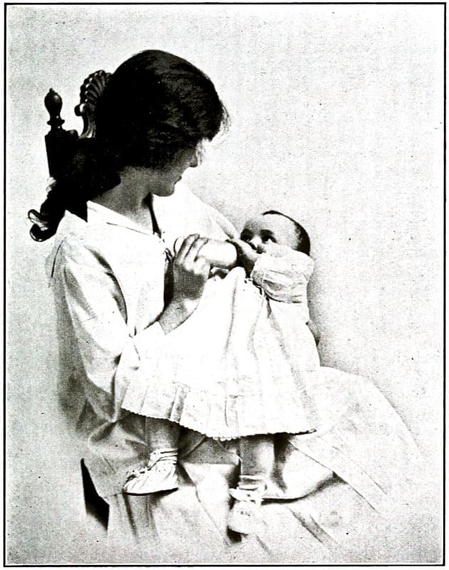 A girl feeding a baby with a bottle